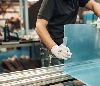 Acrylic Fabrication. Technician bends a clear plexiglass sheet.